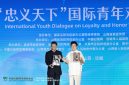 Li Zijun (right), a scholar of the Chinese Theatre Literature Society, displays a photo of his grandfather, Li Hongchun, portraying the legendary Chinese figure Guan Gong during the International Youth Dialogue on Loyalty and Honor Without Borders in Yuncheng, Shanxi province, on Wednesday. [Photo by Zhu Xingxin/China Daily]